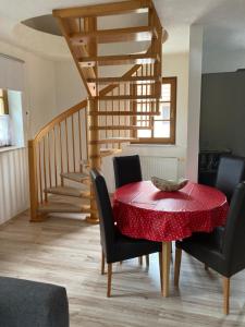 a dining room with a red table and chairs at Ferienwohnung Haubitz in Borna
