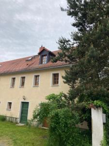 a house with a green door and a tree at Ferienwohnung Haubitz in Borna