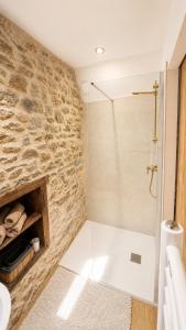 a bathroom with a white tub and a stone wall at Chambres d'Hôtes du Manoir du Haut Salmon in Saint Malo +29 photos