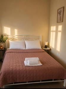 a bedroom with a bed with two towels on it at Casa Polyxeni -Elegant Stay in Vathi in Samos