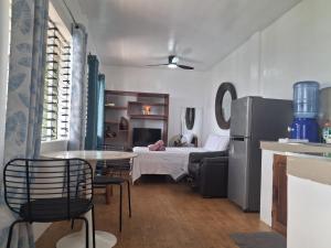 a kitchen and living room with a table and a refrigerator at el balcon camiguin in Mambajao