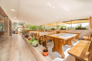 a restaurant with wooden tables and potted plants at Hotel Riviera in Starigrad
