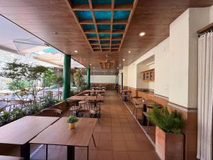 ein Restaurant mit Holztischen und Stühlen in einer Cafeteria in der Unterkunft Hostal ROM Familiar in Roses