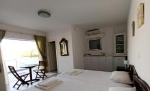 a bedroom with a bed and a table and a kitchen at Socrates in Elafonisos