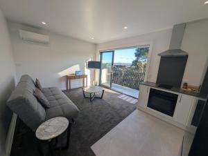 a living room with a couch and a large window at Gumlands Retreat in Auckland