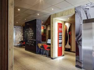 a restaurant with a bar with stools in a lobby at ibis Hyeres Centre in Hyères