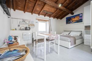 a room with a bed and a table and a kitchen at Franciacorta White in Cellatica