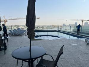 a table and chairs and an umbrella on top of a building at Elegant Sea View Apartment in Ajman 