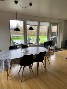 a dining room with a large table and chairs at Beautiful bright summer cottage in Skovbyballe