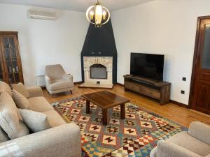 a living room with a fireplace and a tv at Kleo Cottages in Kalkan