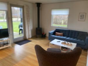 a living room with a blue couch and a table at Beautiful bright summer cottage in Skovbyballe