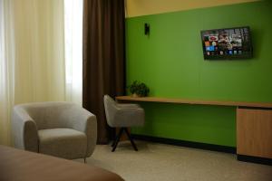 a room with a green wall with a chair and a desk at BVS Hotel in Ukrayinka