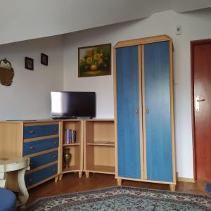 a living room with a blue cabinet and a tv at Złota Rybka in Rowy