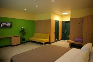 a bedroom with a bed and a yellow chair at BVS Hotel in Ukrayinka