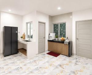 a kitchen with a sink and a refrigerator at Skyn Heaven Penthouse in Tanah Rata