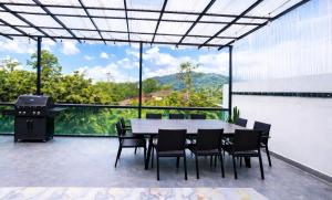 a patio with a table and chairs and a grill at Skyn Heaven Penthouse in Tanah Rata