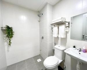 a white bathroom with a toilet and a sink at Skyn Heaven Penthouse in Tanah Rata