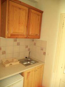 a kitchen with a sink and wooden cabinets at Mario Rooms in Vasiliki +31 photos