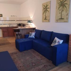 a blue couch in a living room with a kitchen at Złota Rybka in Rowy