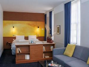 a hotel room with a bed and a couch at Mercure Rouen Centre Cathédrale in Rouen +150 photos