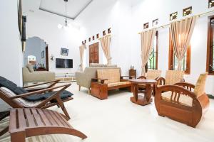 a living room with wooden chairs and tables at Ndalem Artho in Beran-kidul
