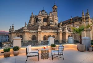 a building with chairs and a table in front of it at Gran Hotel Claridge Granada - Preferred Hotels & Resorts in Granada