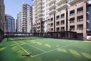 a tennis court in front of some tall buildings at Rendezvous Heritage Hotel Auckland in Auckland