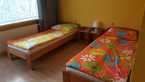 ポドグジンにあるDom wczasowy Lubuszaninのベッドが2つとランプ付きのテーブルがある部屋 +19枚の写真