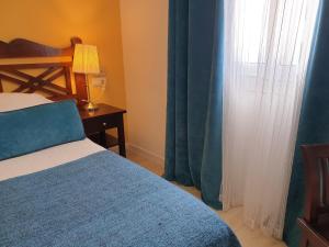 a bedroom with a bed and a window with curtains at Hotel Boutique Las Arenas in Es Cana