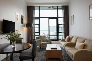 a living room with a couch and a table at Rendezvous Heritage Hotel Auckland in Auckland