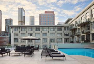a building with a pool and chairs and an umbrella at Rendezvous Heritage Hotel Auckland in Auckland