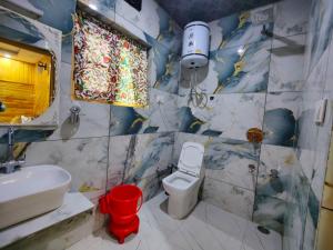 a bathroom with a white toilet and a sink at Hotel The Apple Estate in Pahalgām