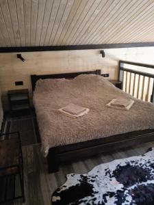 a bedroom with a bed with two towels on it at Котедж Арпад in Synevyr