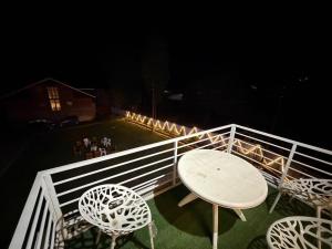 a table and chairs on a balcony at night at Hotel The Apple Estate in Pahalgām