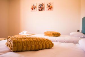 a room with two beds with towels on them at Moby Dick Guesthouse in Atouguia da Baleia