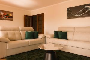 a living room with two couches and a table at Moby Dick Guesthouse in Atouguia da Baleia