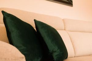 two green pillows sitting on a couch at Moby Dick Guesthouse in Atouguia da Baleia +32 photos