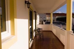 a balcony with chairs and a view of a street at Moby Dick Guesthouse in Atouguia da Baleia