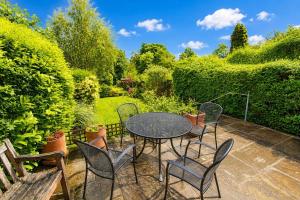 a patio with a table and chairs and bushes at Hill Cottage, Braithwaite with garden and fell views, dog friendly walks from the door, close to Bassenthwaite in Braithwaite