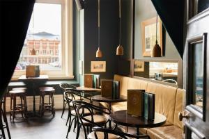 a restaurant with tables and chairs and a window at Adina Heritage Christchurch in Christchurch