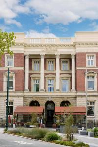 a large brick building on the corner of a street at Adina Heritage Christchurch in Christchurch