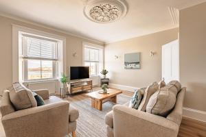 a living room with two chairs and a tv at At Anchor (with a Harbour View) in Fife