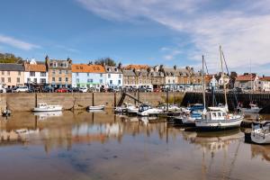 a group of boats are docked in a harbor at At Anchor (with a Harbour View) in Fife