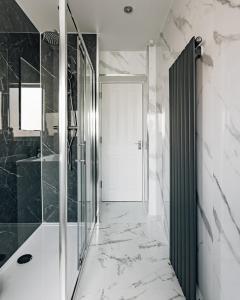 a bathroom with a walk in shower and a glass door at At Anchor (with a Harbour View) in Fife +44 photos