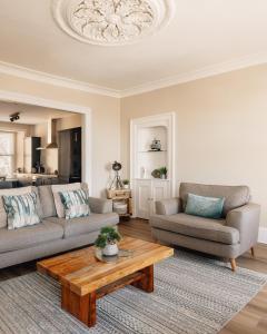 a living room with two couches and a coffee table at At Anchor (with a Harbour View) in Fife
