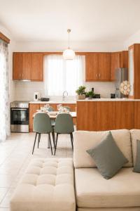 a living room with a couch and a table with chairs at Indaba Luxury Apartments in Myrina