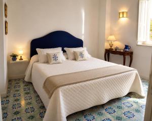a bedroom with a large bed with a blue headboard at Villa Positano with sea view ! in Positano +25 photos