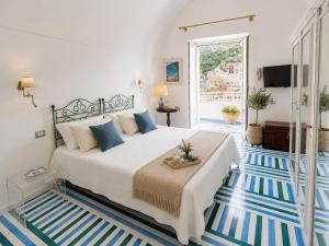 a bedroom with a large bed with blue and white floors at Villa Positano with sea view ! in Positano