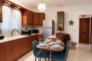 a kitchen with a table and chairs and a refrigerator at Indaba Luxury Apartments in Myrina +37 photos