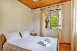 a bedroom with a white bed and a window at Villa Liana in Frikes